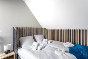 a bed with towels and pillows on it at Green Park Resort A25 -z dostępem do basenu, sauny, jacuzzi, siłowni in Szklarska Poręba