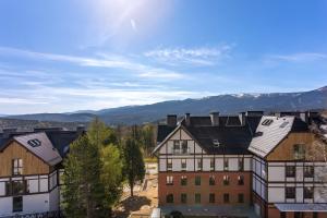 a group of buildings with mountains in the background at Green Park Resort A25 -z dostępem do basenu, sauny, jacuzzi, siłowni in Szklarska Poręba