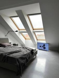 ein Schlafzimmer mit einem Bett in einem Zimmer mit Oberlichtern in der Unterkunft Raguvos Apt. in Kaunas