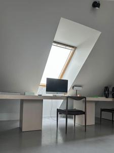 einen Schreibtisch mit einem Computer und einem Fenster in der Unterkunft Raguvos Apt. in Kaunas
