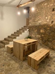 a room with a table and benches and stairs at Casa dos Copos - Drinks House in Miranda do Corvo