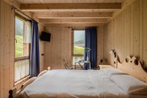 a bedroom with a large bed and a window at Hotel Chalet val di Rabbi in Rabbi