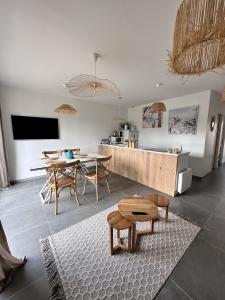 eine Küche und ein Esszimmer mit einem Tisch und Stühlen in der Unterkunft L'Opale - Le White in Les Attaques