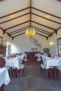 um restaurante com mesas e cadeiras brancas e um lustre em Kili Seasons Hotel em Arusha