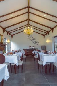 a restaurant with white tables and chairs and a chandelier at Kili Seasons Hotel in Arusha