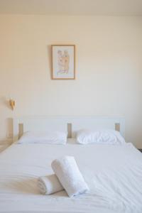 Una cama blanca con dos toallas encima. en Shifra Suite en Beer Sheva