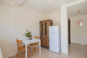 a kitchen with a white table and a refrigerator at Shifra Suite in Beer Sheva