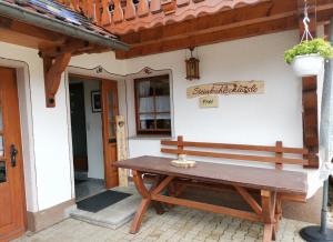 a wooden bench sitting outside of a building at Steinbühlschlössle in Schönwald