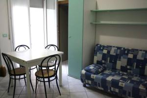 Cette chambre comprend une table, des chaises et un lit. dans l'établissement Residence Le Vele, à Cattolica