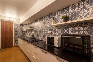 a kitchen with blue and white tiles on the wall at StayVista at Mawi Infinitty Beach View Villa - Arambol in Arambol