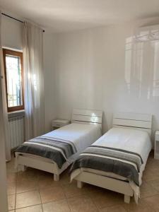 ファザーノにあるVilla Ninaのベッド2台が隣同士に設置された部屋です。