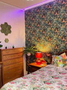 a bedroom with a bed with a flower patterned wall at Home and Relax ROOMS in Furnari +47 photos
