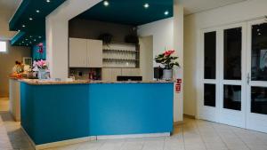 a kitchen with a blue counter in a room at Hotel Kaly in Ventimiglia