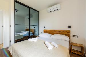 een slaapkamer met 2 bedden en spiegelwanden bij Villa Ecija in Trogir