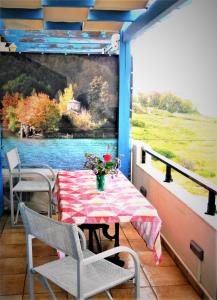 einen Tisch und Stühle auf einem Balkon mit Gemälde in der Unterkunft Laconian Collection ''Le Bleu Infini'' in Monemvasia