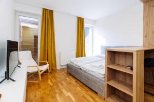 une chambre avec un lit, un bureau et une télévision dans l'établissement Horský apartmán Temari 11 Klínovec, à Loučná pod Klínovcem