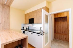 une cuisine avec des armoires blanches et un évier dans l'établissement Horský apartmán Temari 11 Klínovec, à Loučná pod Klínovcem