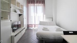 a white bedroom with a bed and a television at Italianway - Voghera 11 B in Milan