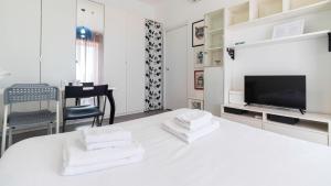a white bedroom with a bed with towels on it at Italianway - Voghera 11 B in Milan