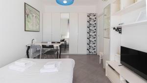 a bedroom with a white bed and a dining room at Italianway - Voghera 11 B in Milan