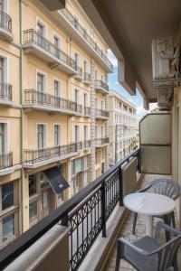 un balcone con tavolo e sedie e un edificio di Central Spacious Apt close to port-sites w/view 2 a Heraklion