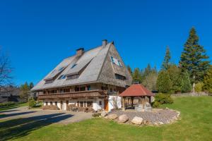 ein großes Haus mit einem Gamer-Dach mit einem Pavillon in der Unterkunft Ferienwohnung im Hubertushof in Feldberg