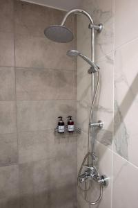 una doccia con due bottiglie su una mensola in bagno di Central Spacious Apt close to port-sites w/view 2 a Heraklion
