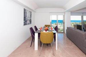 un comedor con mesa y sillas y el océano en Apartment Marina - Beachfront, en Protaras