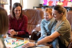 dos mujeres y una chica jugando un juego de mesa en Rozprávková HÁJENKA v Nízkych Tatrách, en Brezno