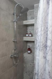 La salle de bains est pourvue d'une douche avec rideau de douche. dans l'établissement Central Spacious Apt close to port-sites w/view 2, à Héraklion