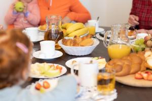 einen Tisch mit Teller mit Lebensmitteln und Gläsern Orangensaft in der Unterkunft Rozprávková HÁJENKA v Nízkych Tatrách in Brezno