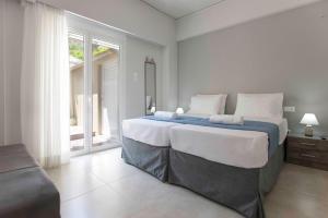 een slaapkamer met een groot bed en een groot raam bij Central Spacious Apt close to port-sites w/view 2 in Heraklion