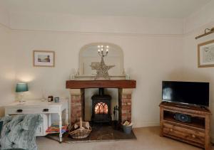 a living room with a fireplace and a tv at Kingston House in West Witton