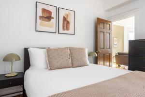 a bedroom with a white bed and two pictures on the wall at Beacon Hill 2br w wd nr Boston Common BOS-826 in Boston