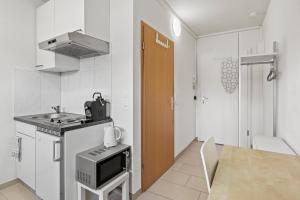 a small white kitchen with a sink and a stove at Excellent Connection-Central-Coffee-Washer in Basel