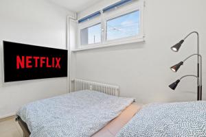 a bedroom with a bed and a window and a netflix sign at Excellent Connection-Central-Coffee-Washer in Basel