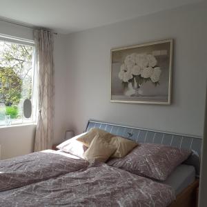 a bedroom with a bed with a vase on the wall at Bi uns im Norden in Brunsbüttel