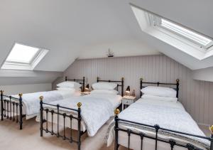 two beds in a attic bedroom with a skylight at Juniper in Whitby