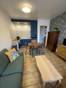 een woonkamer met een bank en een tafel bij Gîte « Le Marie » in Saint-Martin-aux-Buneaux