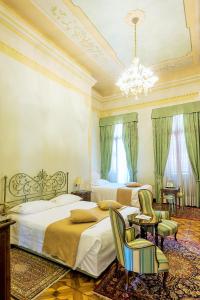 Habitación grande con 2 camas y lámpara de araña. en Villa Ducale Hotel & Ristorante en Dolo