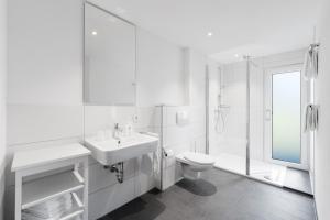 a white bathroom with a sink and a toilet at Ferienwohnung im Hubertushof in Feldberg +27 photos