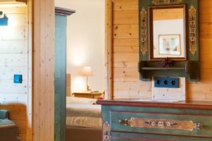 a bedroom with a bed and a dresser with a mirror at Ferienwohnung im Hubertushof in Feldberg
