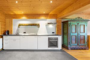 a kitchen with white appliances and a wooden ceiling at Ferienwohnung im Hubertushof in Feldberg