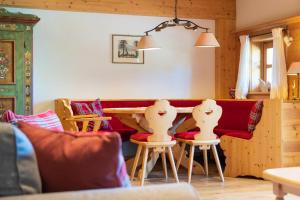 a living room with a red couch and chairs at Ferienwohnung im Hubertushof in Feldberg