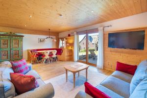 a living room with a couch and a tv and a table at Ferienwohnung im Hubertushof in Feldberg