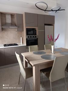 - une cuisine avec une table à manger en bois et des chaises dans l'établissement Lilly's Sea view, beachfront apartment, à Marsalforn
