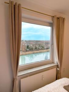 a window in a bedroom with a view of a river at REGENCY Apartments - Stylische zentrale 50m2 Wohnung mit Balkon, Wasserblick und Netflix in Hannover