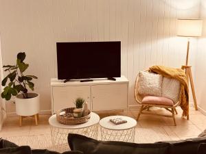 a living room with a tv and a chair at Cooly Coastal Escape walk to beach & shops in Gold Coast