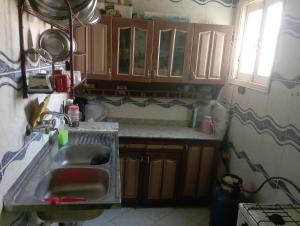 una cucina con lavandino e armadi in legno di Large and cheerful home with 2 floors a Fayoum