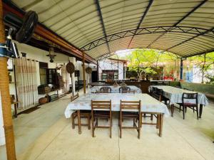 ein Esszimmer mit einem Tisch, Stühlen und einem Waschbecken in der Unterkunft Mangala Lodge in Kurunegala